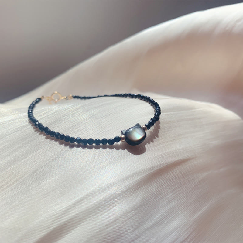 Carmiora 14K vergoldetes schwarzes Spinell-weißes Kristall-Heilarmband mit süßer Katze aus Tridacna-Stein