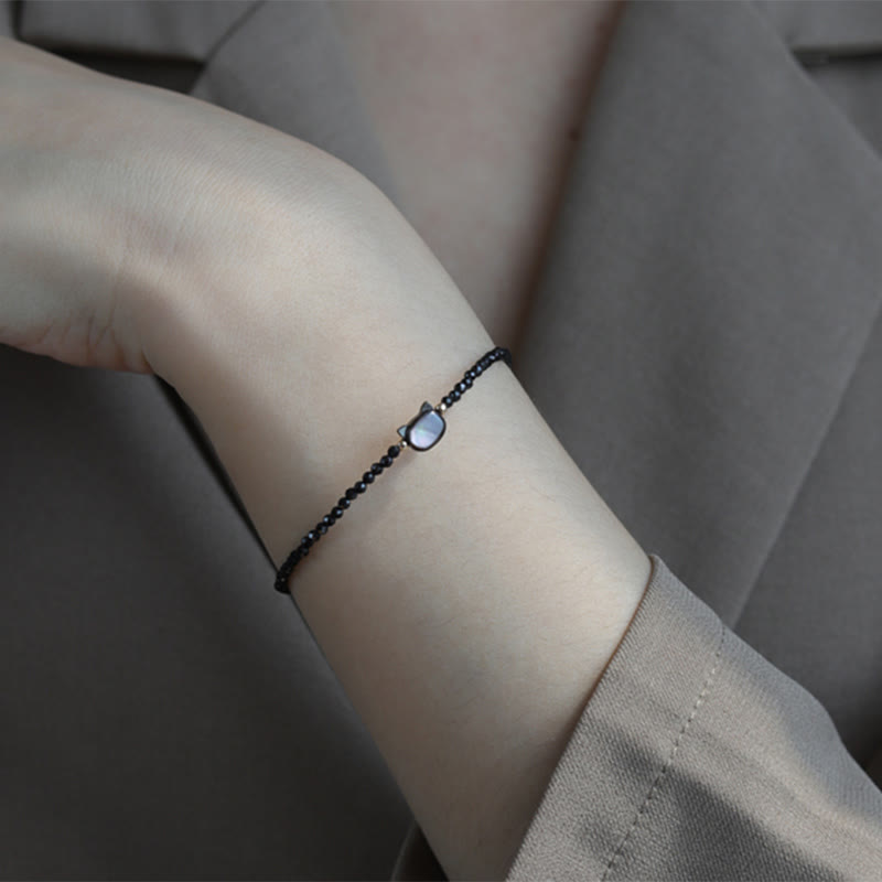 Carmiora 14K vergoldetes schwarzes Spinell-weißes Kristall-Heilarmband mit süßer Katze aus Tridacna-Stein