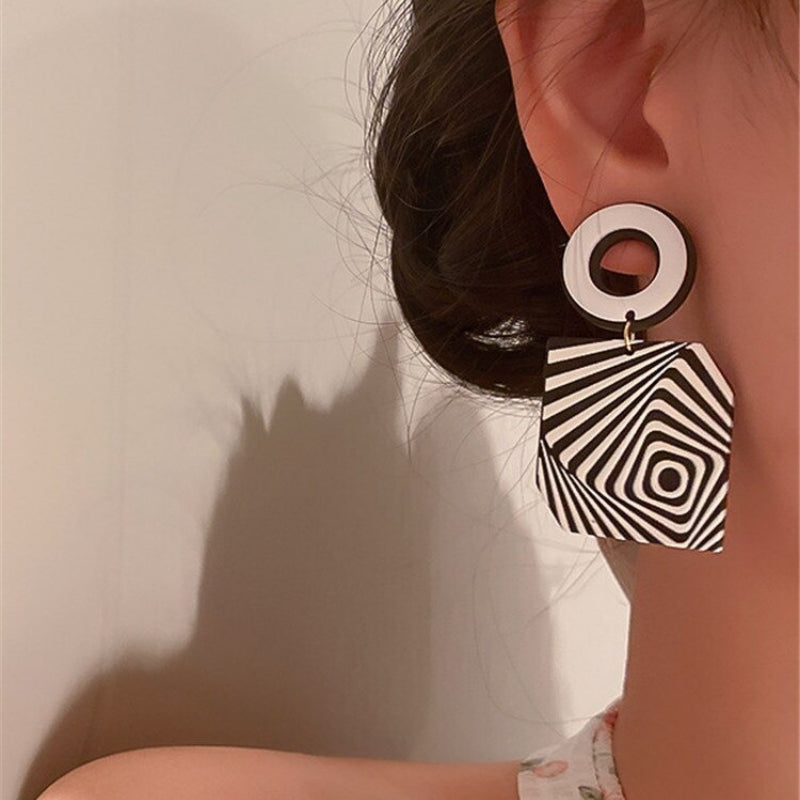 Künstlerische und hypnotische schwarz-weiße geometrische Tropfenohrringe