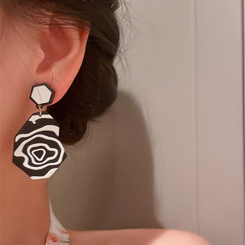 Künstlerische und hypnotische schwarz-weiße geometrische Tropfenohrringe