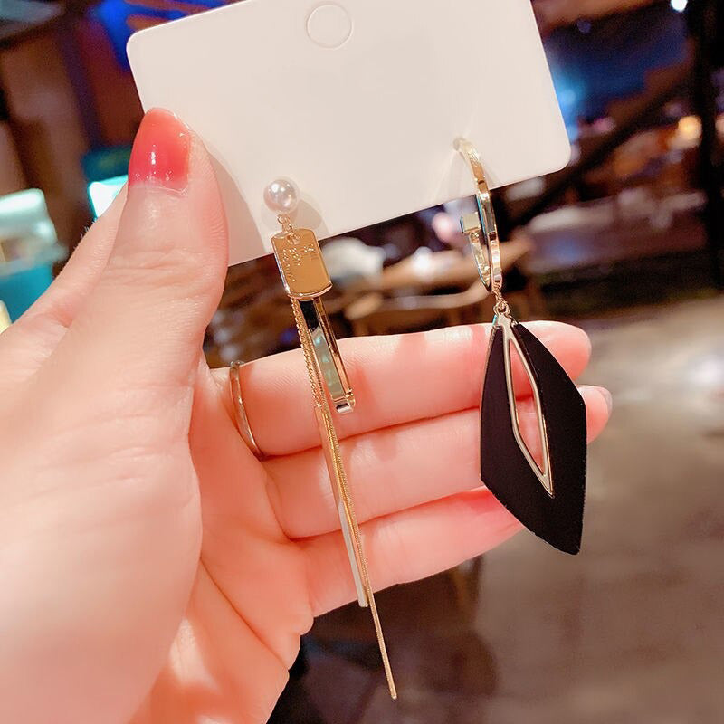 Asymmetrische hohle Liebesherz-Ohrringe mit langer Quaste