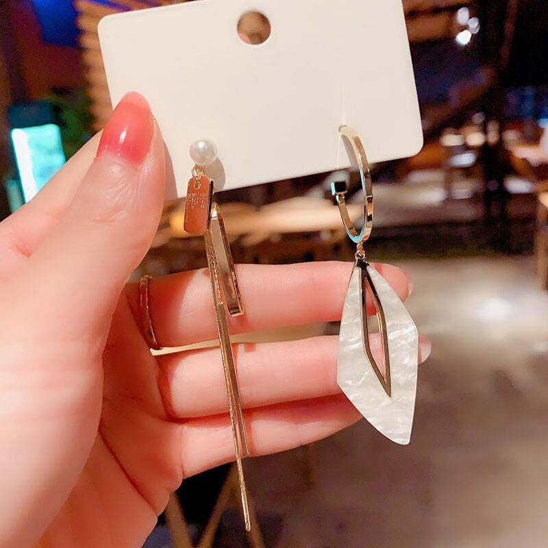 Asymmetrische hohle Liebesherz-Ohrringe mit langer Quaste