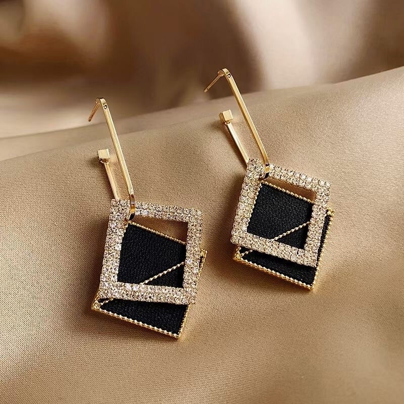 Asymmetrische hohle Liebesherz-Ohrringe mit langer Quaste