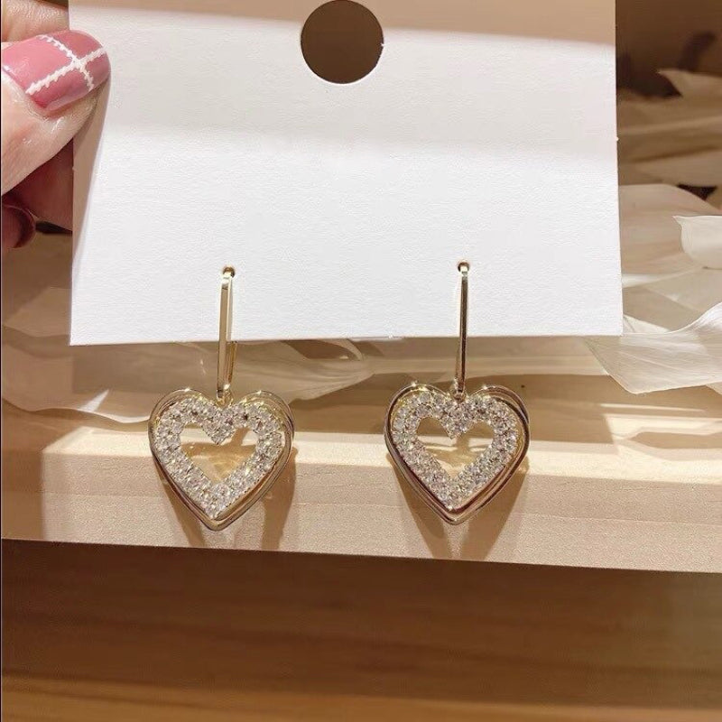 Asymmetrische hohle Liebesherz-Ohrringe mit langer Quaste