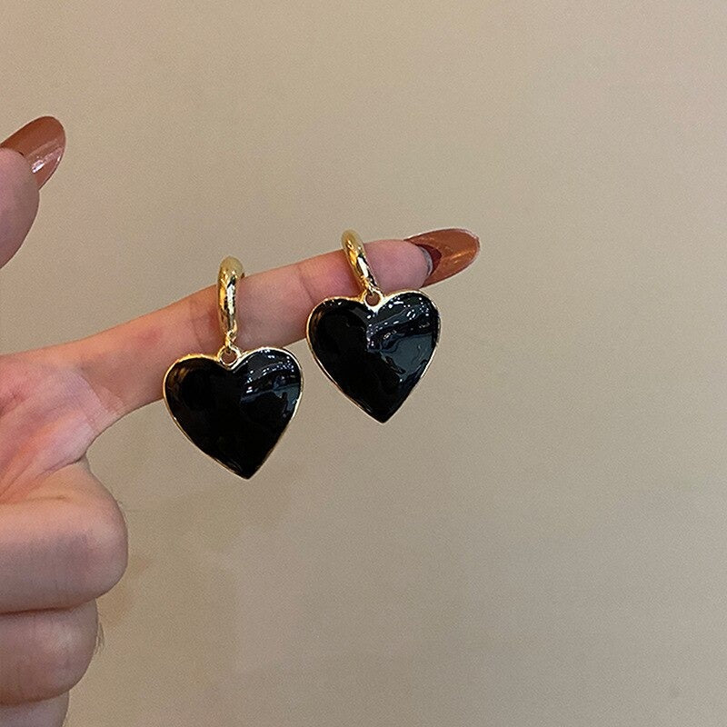 Asymmetrische hohle Liebesherz-Ohrringe mit langer Quaste