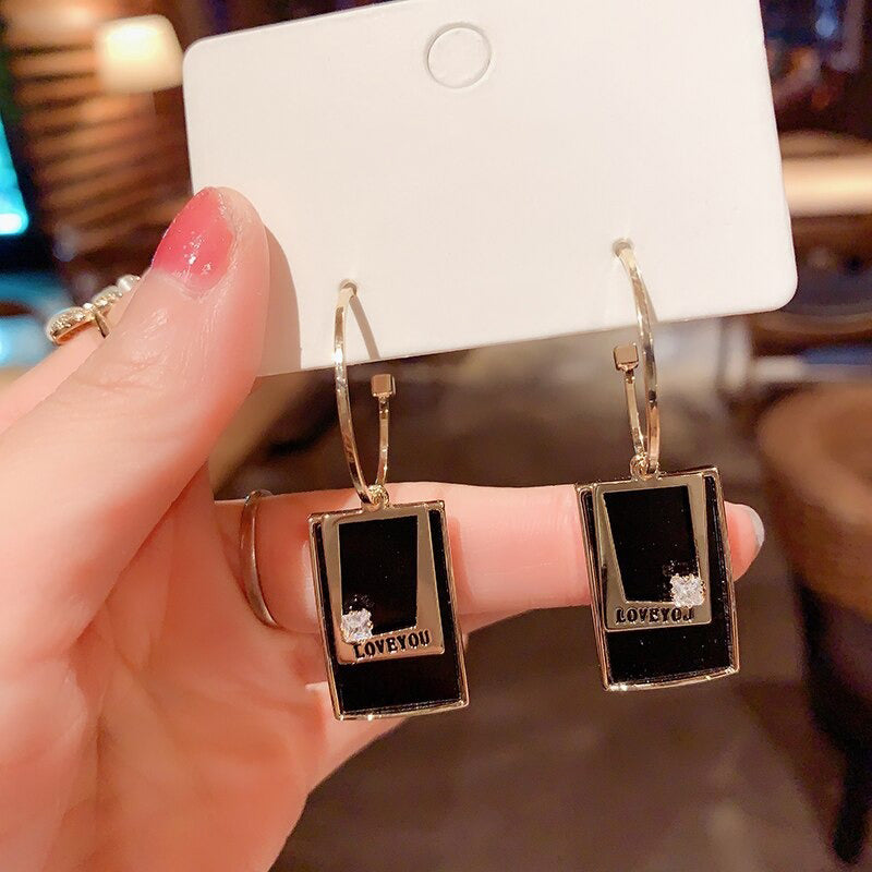 Asymmetrische hohle Liebesherz-Ohrringe mit langer Quaste