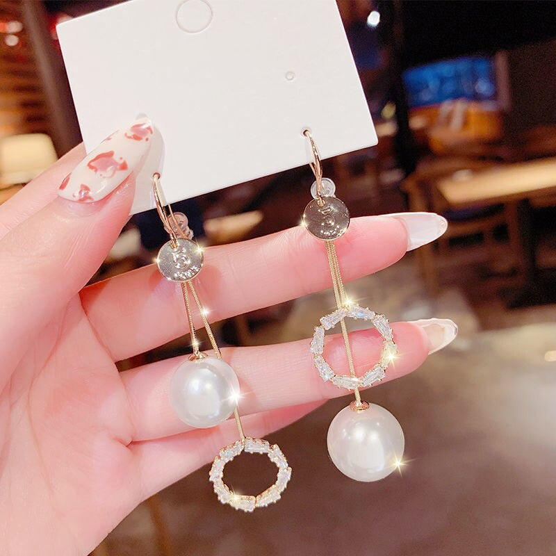 Asymmetrische hohle Liebesherz-Ohrringe mit langer Quaste