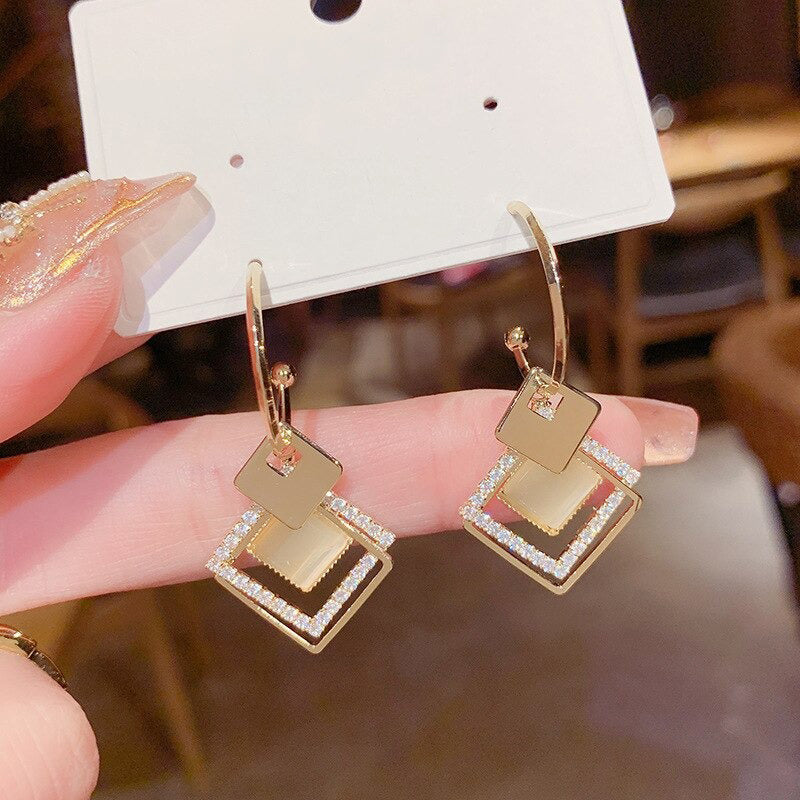 Asymmetrische hohle Liebesherz-Ohrringe mit langer Quaste