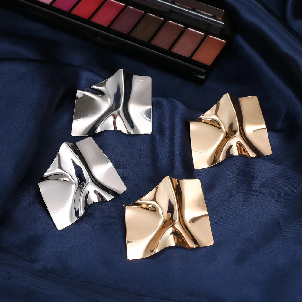 Moderne geometrische Goldohrringe - gedrehter, abstrakter, skulpturaler Schmuck