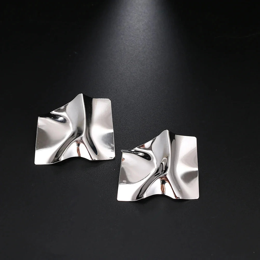 Moderne geometrische Goldohrringe - gedrehter, abstrakter, skulpturaler Schmuck