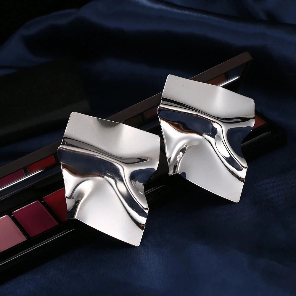 Moderne geometrische Goldohrringe - gedrehter, abstrakter, skulpturaler Schmuck