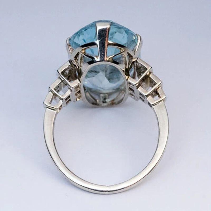 Schillernder blauer Zirkonring mit seitlichen Strass-Akzenten