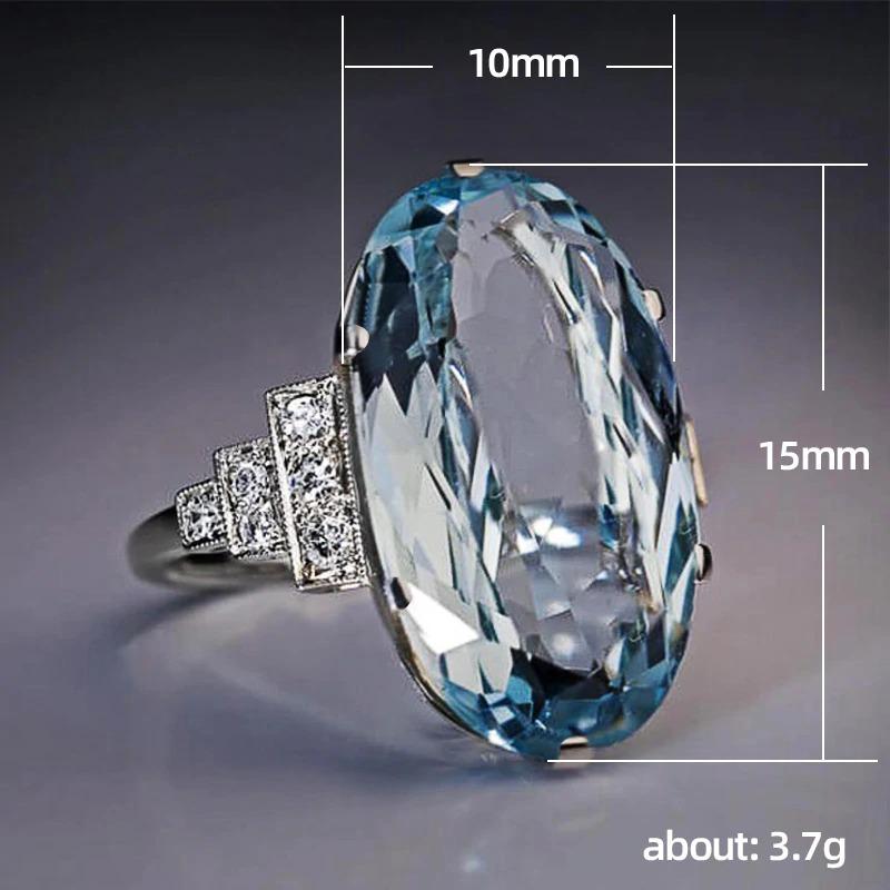 Schillernder blauer Zirkonring mit seitlichen Strass-Akzenten