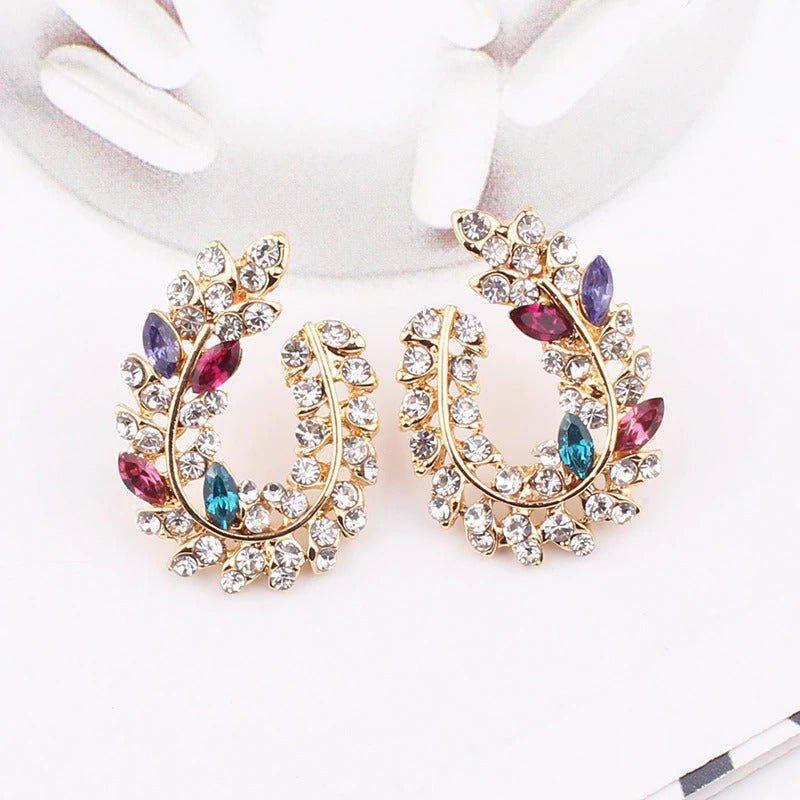 Schillernde, mit Strasssteinen besetzte Ohrstecker aus Acryl in Blattform