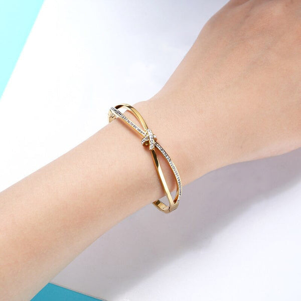 Elegante Armreifen mit geknotetem Kreuz und Zirkonia