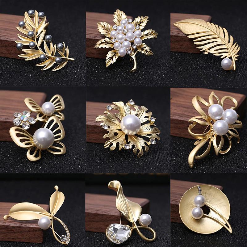 Kollektion goldener Broschennadeln mit Strasssteinen und Perlen