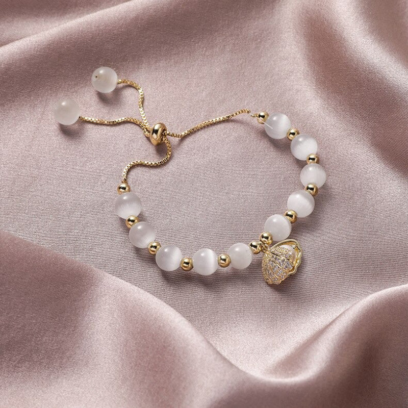 Hochmodisches Armband aus Opalperlen mit einem mit Zirkonen verzierten Perlen-Muschelanhänger