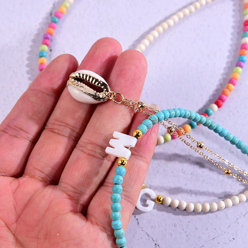 Mehrlagige Muschelkette mit Perlen und personalisiertem Anfangsbuchstaben