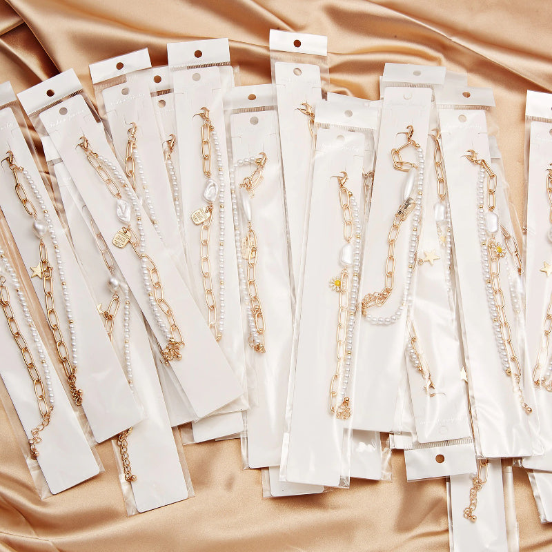 Mehrschichtige Perlen- und Kettenarmband-Schmuckkollektion mit Perlenanhängern