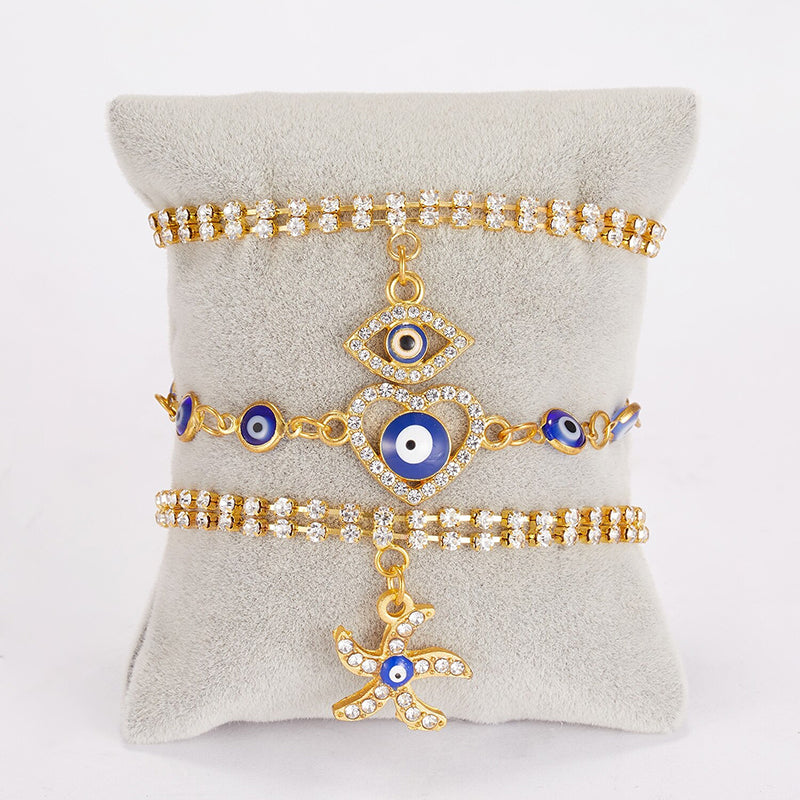Mit Strasssteinen besetzte Hamsa-Hände und blaue Glücksaugen-Charm-Armbänder