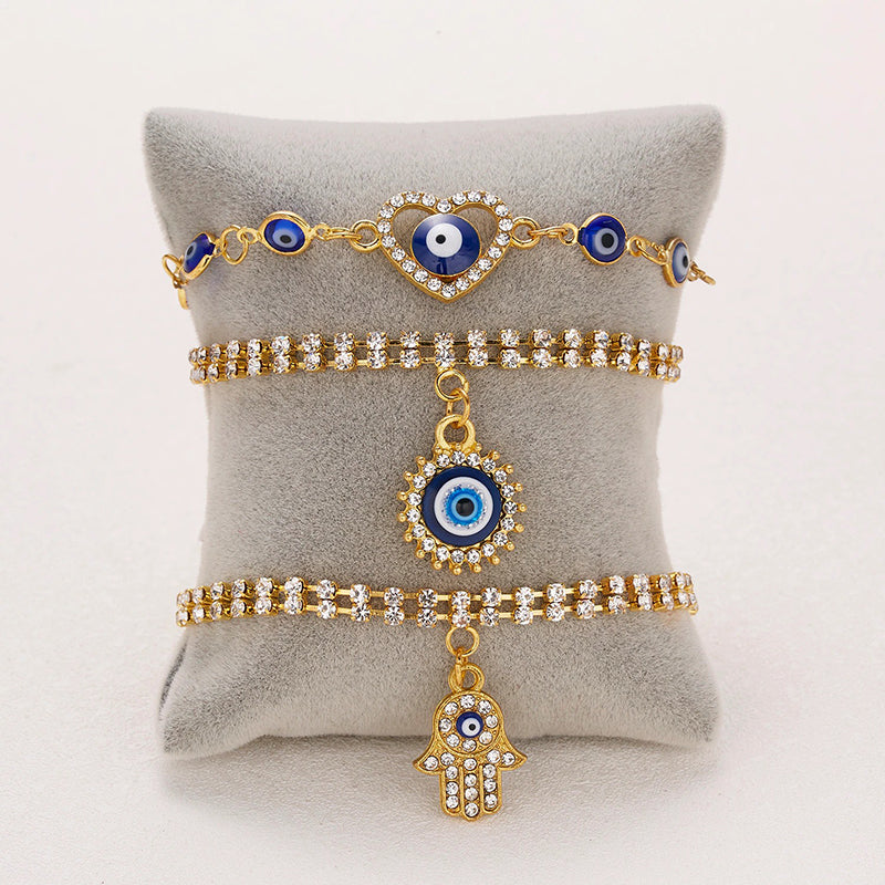 Mit Strasssteinen besetzte Hamsa-Hände und blaue Glücksaugen-Charm-Armbänder