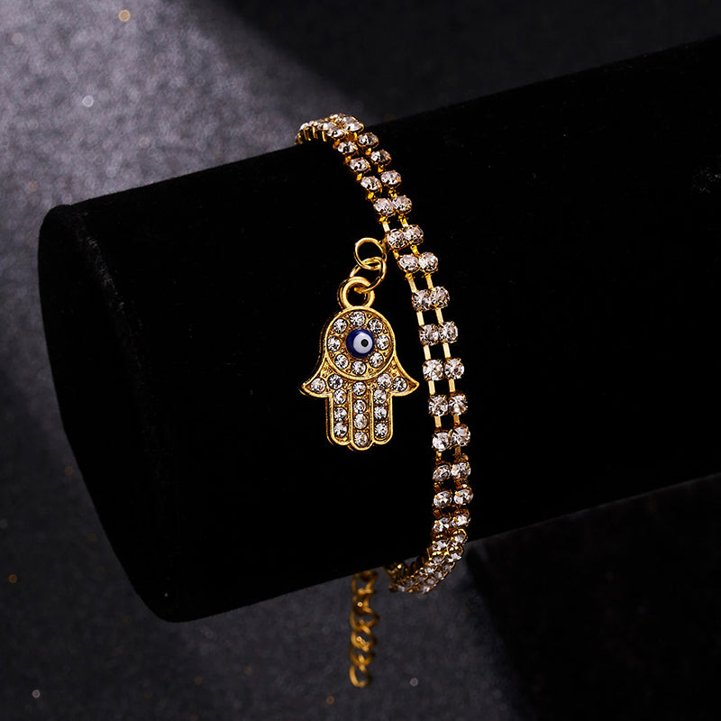 Mit Strasssteinen besetzte Hamsa-Hände und blaue Glücksaugen-Charm-Armbänder