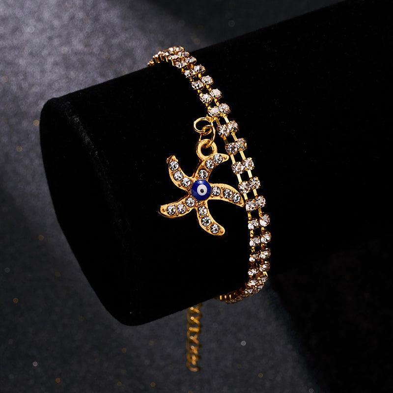 Mit Strasssteinen besetzte Hamsa-Hände und blaue Glücksaugen-Charm-Armbänder