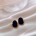 Golden gerahmter Onyx-Ohrring mit mystischem Touch