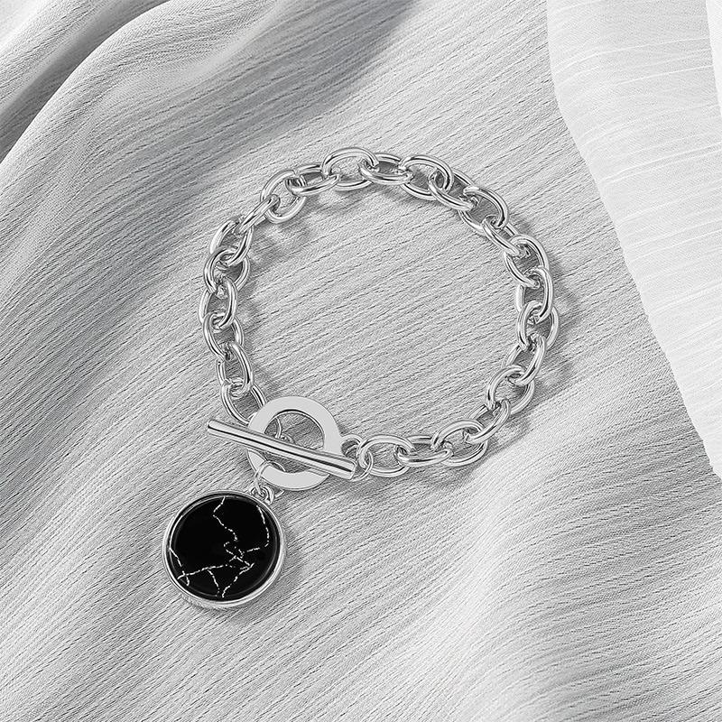 Halskette und Armband mit Anhänger aus glattem, schwarzem Marmor.