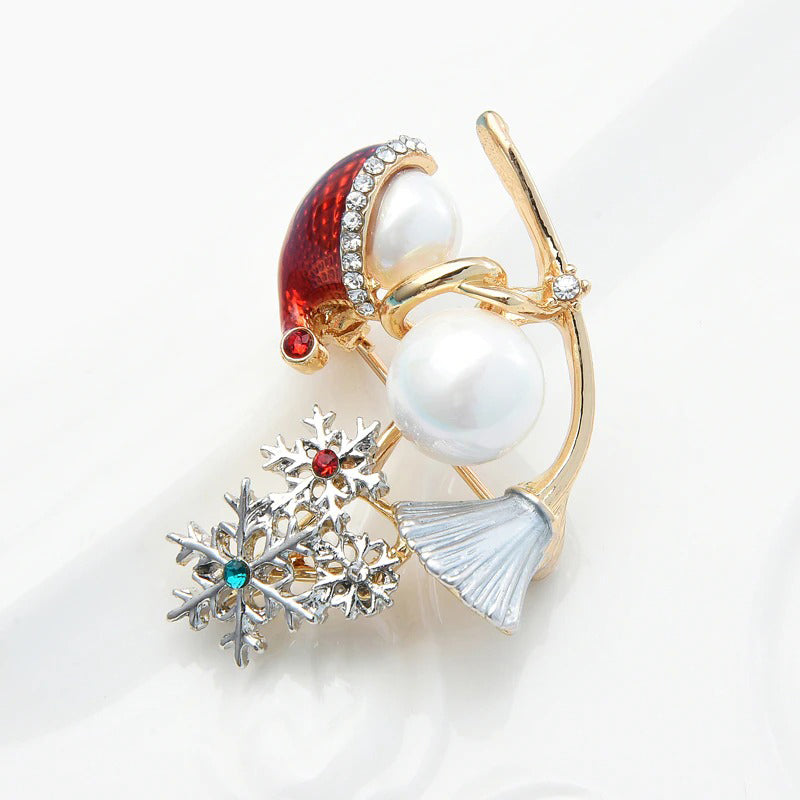 Funkelnde Weihnachts-Brosche mit Schneemann auf einem Besen.