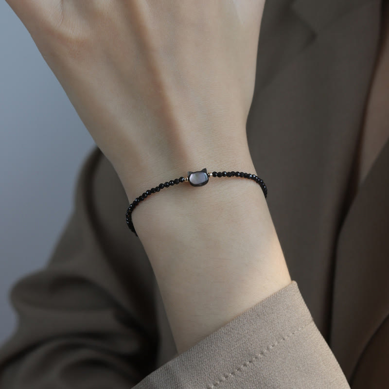 Carmiora 14K vergoldetes schwarzes Spinell-weißes Kristall-Heilarmband mit süßer Katze aus Tridacna-Stein