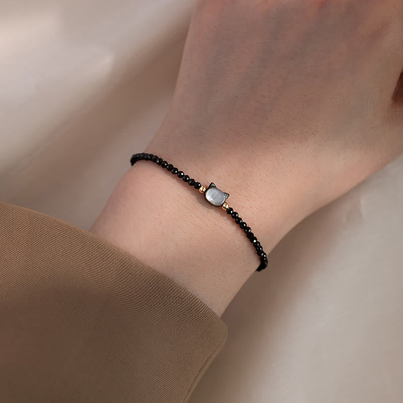 Carmiora 14K vergoldetes schwarzes Spinell-weißes Kristall-Heilarmband mit süßer Katze aus Tridacna-Stein