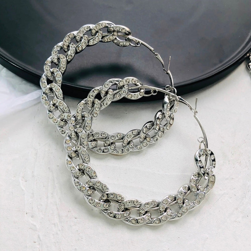 Übergroße, auffällige Creolen mit eingelassenen Strasssteinen und dicken Ketten