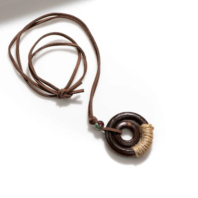 Handgefertigte Halskette mit rundem Holzanhänger im Boho-Stil
