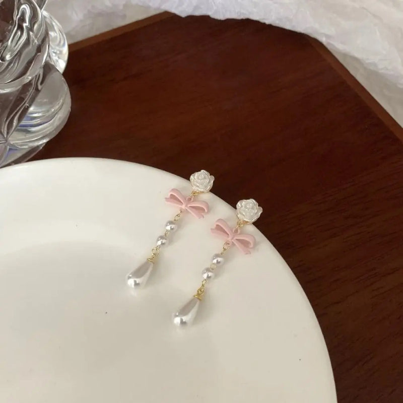 Stilvolle Ohrringe mit Blumenschleife und Perlenanhänger