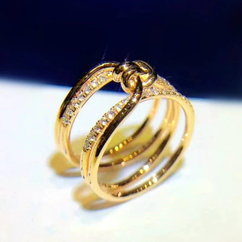 Huitan Kreative Knoten Design Damen Fingerringe Goldfarbenes Accessoire mit funkelnden CZ Party Statement Schmuck